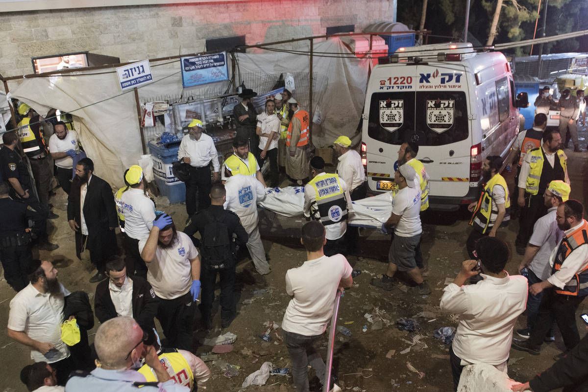 Israeli security officials and rescuers carry a body of a victim who died during a Lag Ba'Omer ...