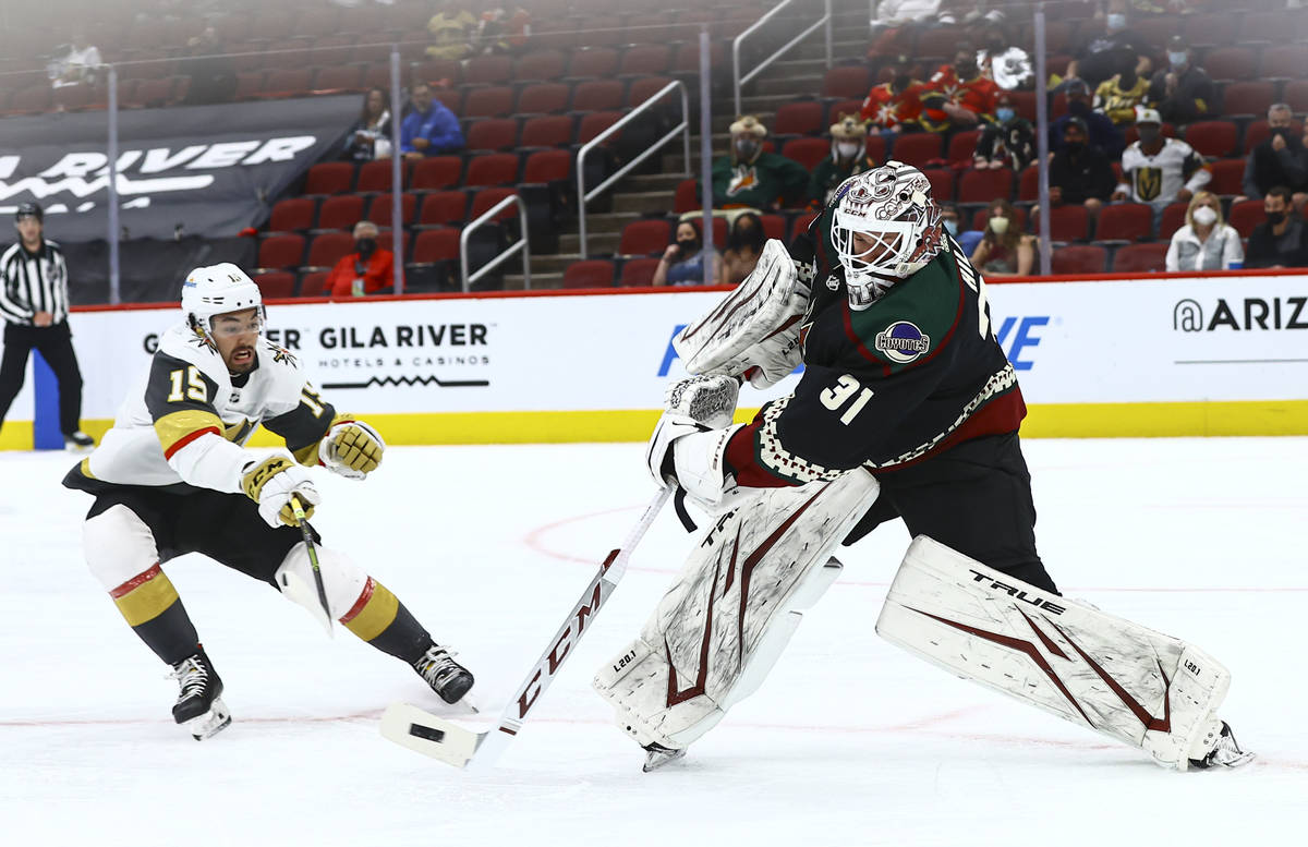Arizona Coyotes' goaltender Adin Hill (31) passes the puck in front of Golden Knights' Dylan Si ...
