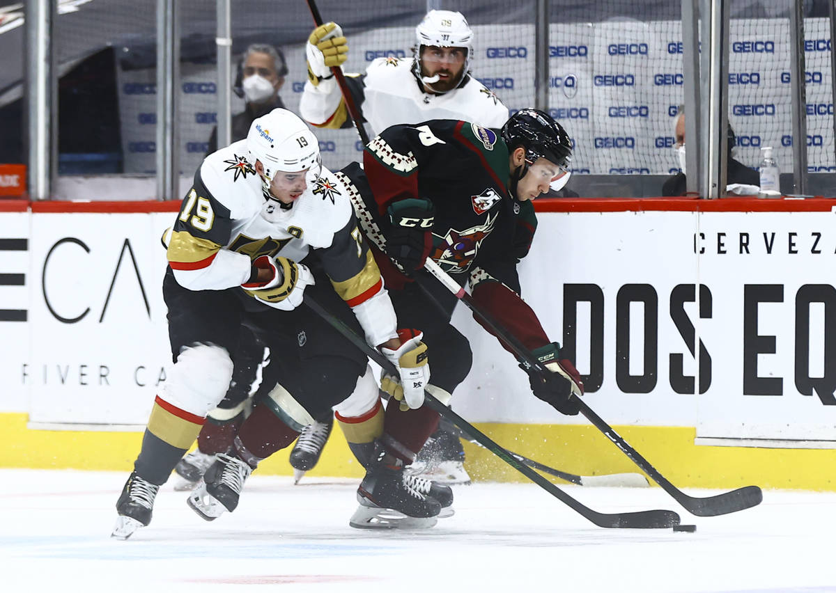 Golden Knights' Reilly Smith (19) and Arizona Coyotes' Michael Bunting (58) battle for the puck ...