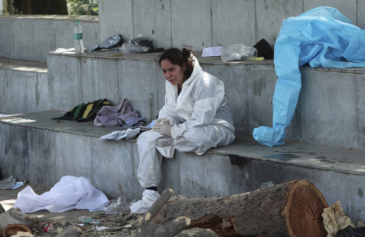 A relative of a person who died of COVID-19 mourns at a crematorium in Jammu, in Jammu, India, ...