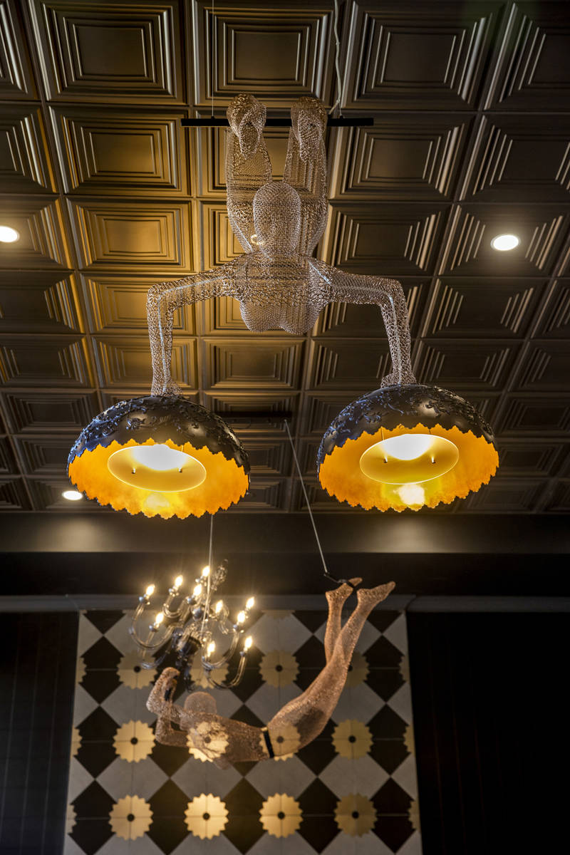 Human-figured wire lighting above the sitting area with fireplace in Elysian at Tivoli, a newly ...