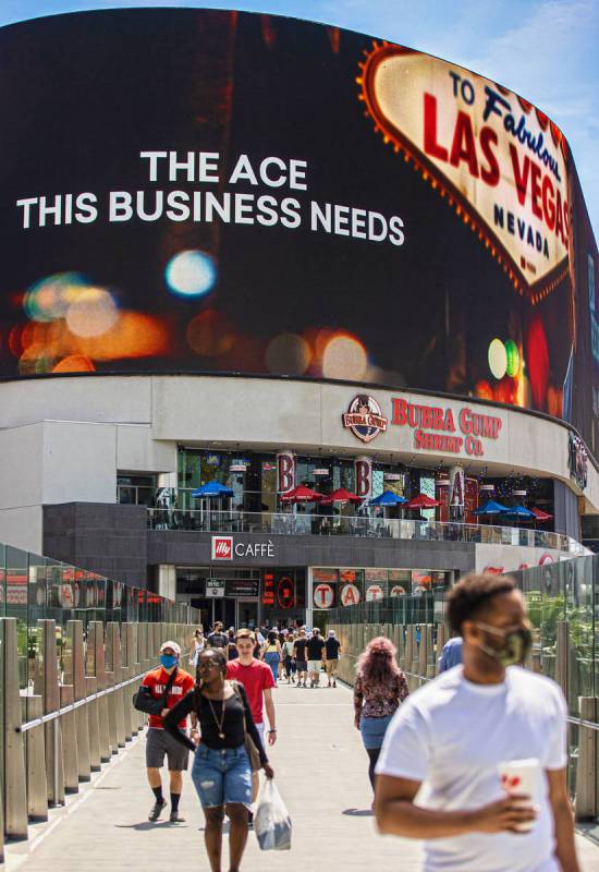 Tourists cross the pedestrian bridge connected to Harmon Corner on the Strip on Friday, April 3 ...