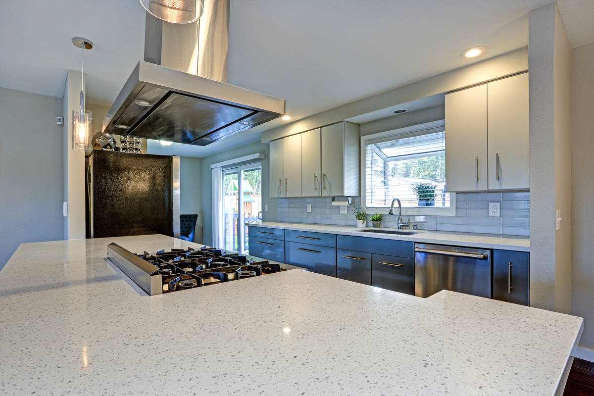 This stylish kitchen has been updated with quartz countertops and stainless steel appliances. ( ...