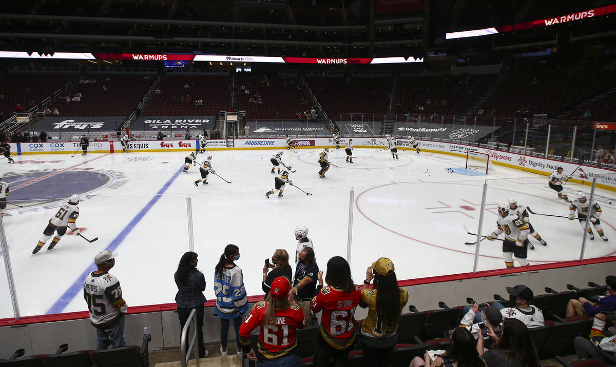 Golden Knights fans watch as players warm up before an NHL hockey game against the Arizona Coyo ...