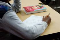 A sixth-grade student writes down math problems during class at Democracy Prep in Las Vegas, Tu ...