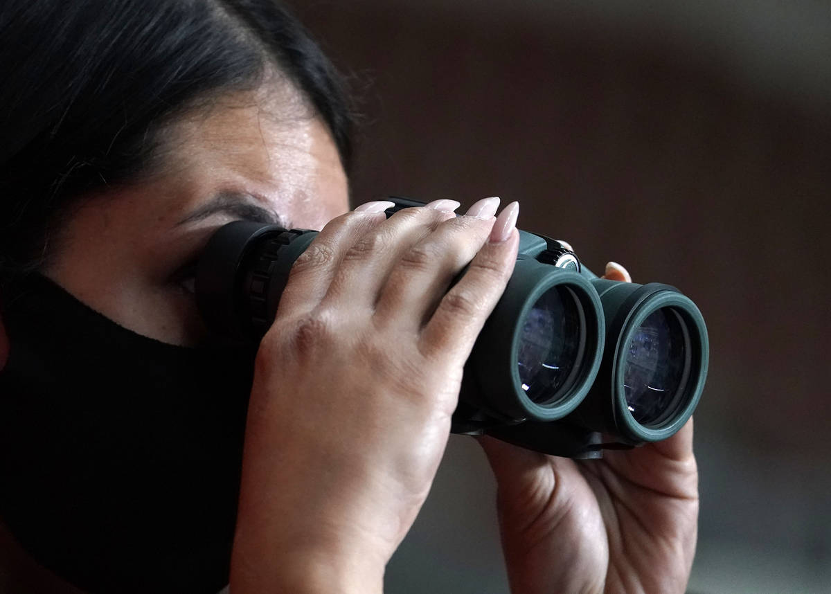 A reporter watches the Maricopa County ballots cast in the 2020 general election being examined ...