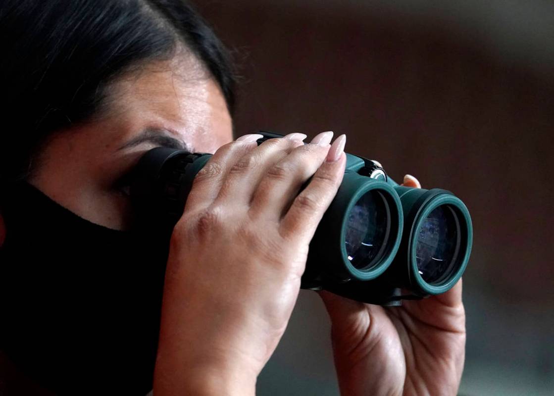 A reporter watches the Maricopa County ballots cast in the 2020 general election being examined ...