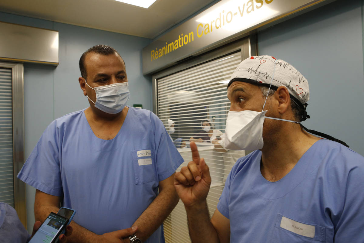 Surgeons Doctor Yazid, left, listens to the clinic's director Youssef Alaoui as they speak to t ...