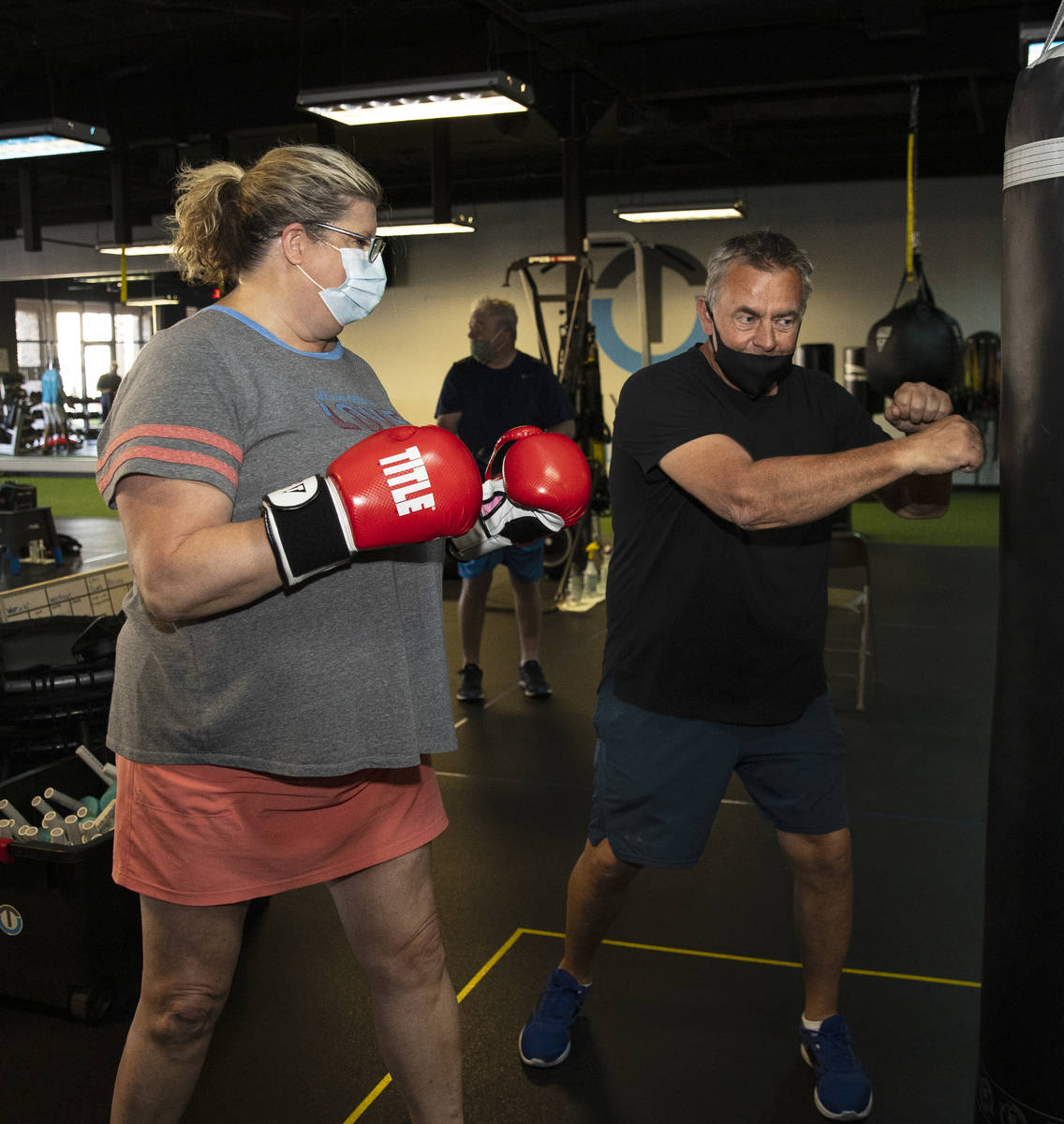 Robert Vlcek, a volunteer trainer, demonstrates to Gwen Vaughn, 48, how to punch the bag during ...