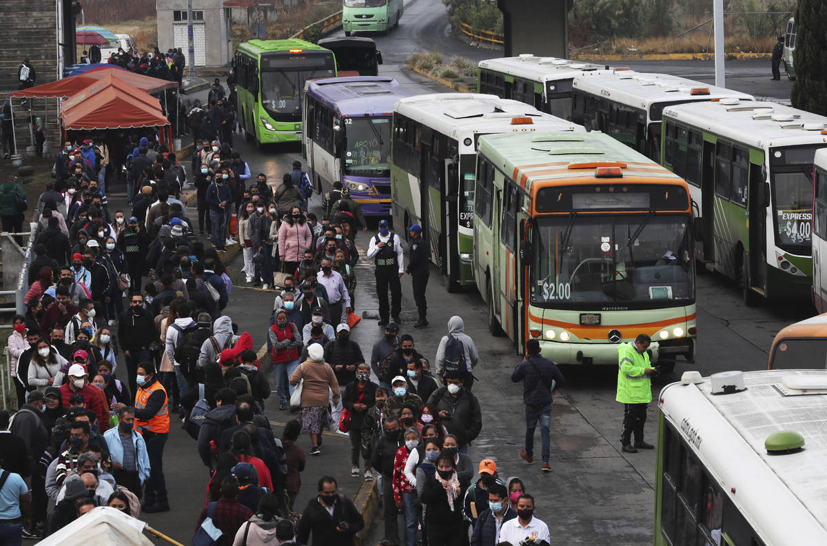 Commuters, most who use the Line 12 subway daily to get across the city, line up to board buses ...