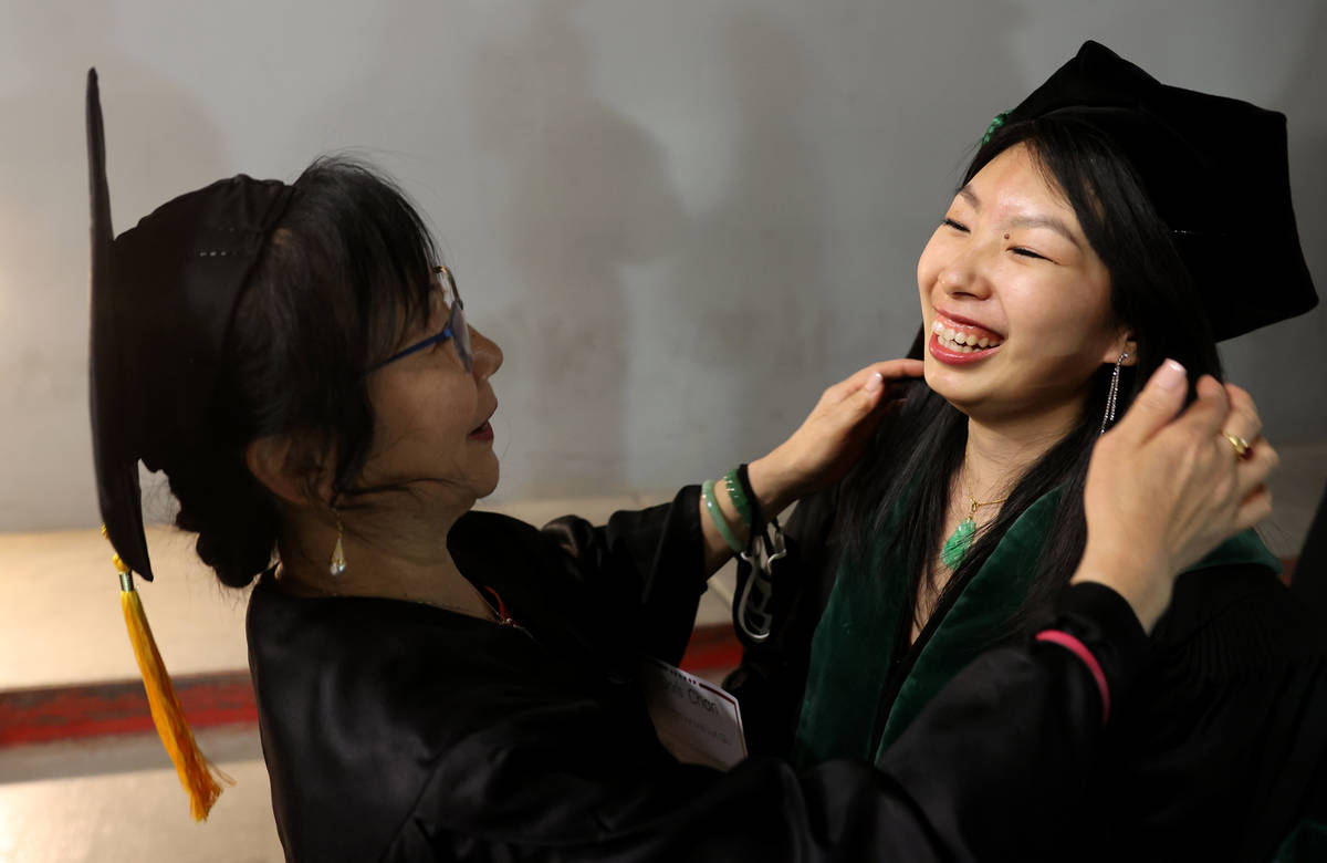 Doris Chan and her mother Mei Lun Qiu, who will do the hooding, prepare before the first gradua ...