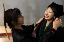 Doris Chan and her mother Mei Lun Qiu, who will do the hooding, prepare before the first gradua ...