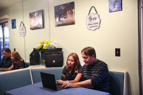 Isabella Wetsel, 12, works on homework with her dad Don Collins at their home in Las Vegas Sund ...