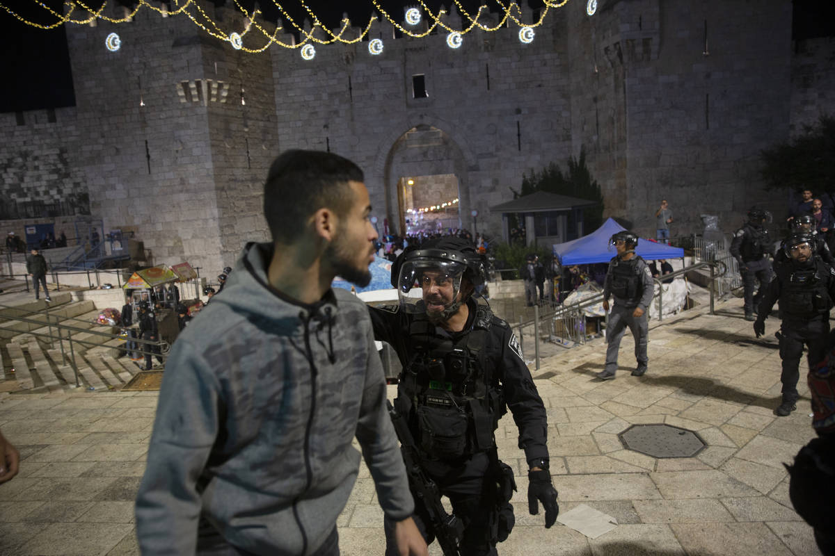An Israeli policeman shouts at a Palestinian man to leave the Damascus Gate to the Old City of ...