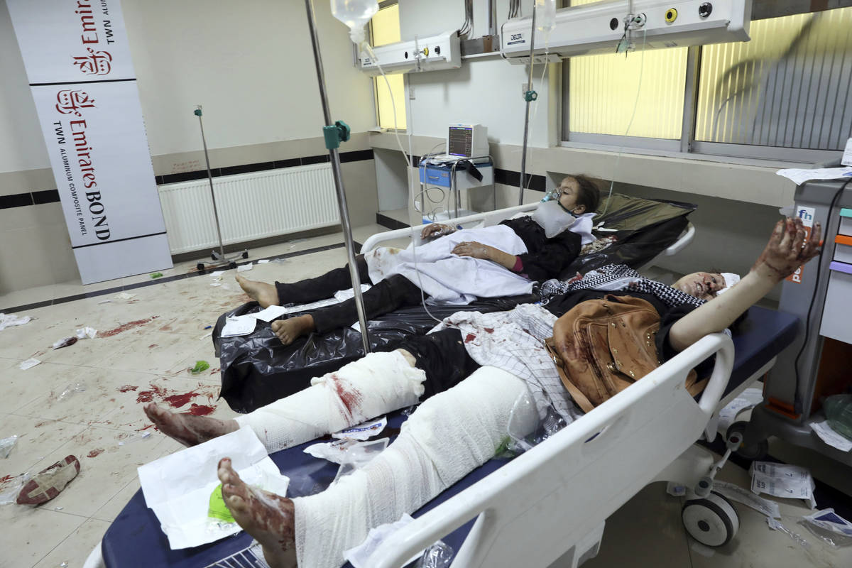 Afghan school students treated at a hospital after a bomb explosion near a school in west of Ka ...