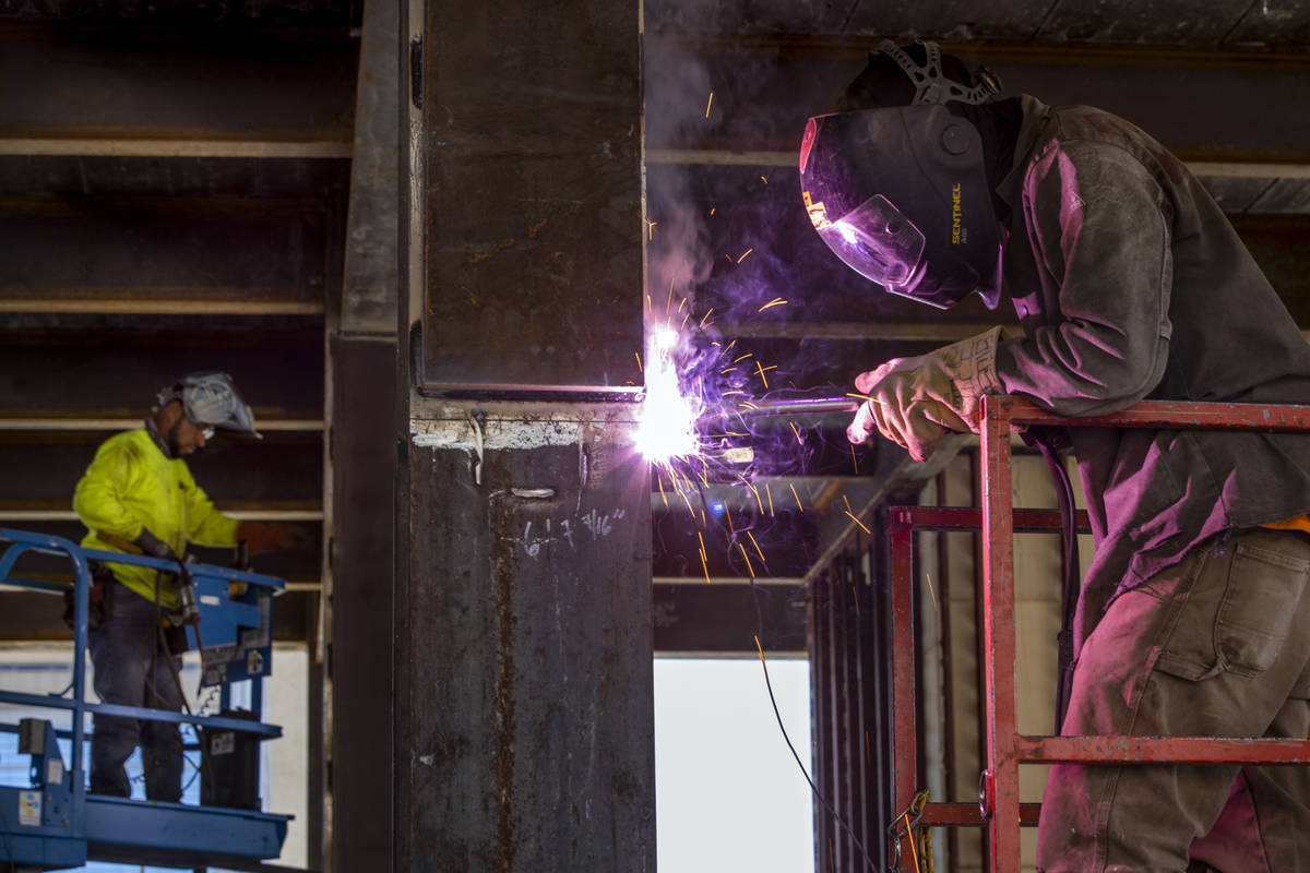 Jay Madrid, right, and Leonardo Mejia with Quality Iron works metal support beams as redevelopm ...