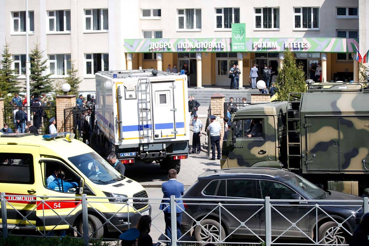 An ambulance and police trucks are parked at a school after a shooting in Kazan, Russia, Tuesda ...