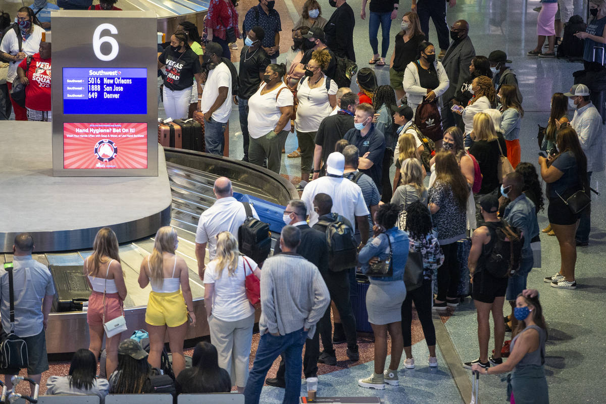 Travelers wait for their luggage at McCarran International Airport Terminal 1 in Las Vegas, Thu ...