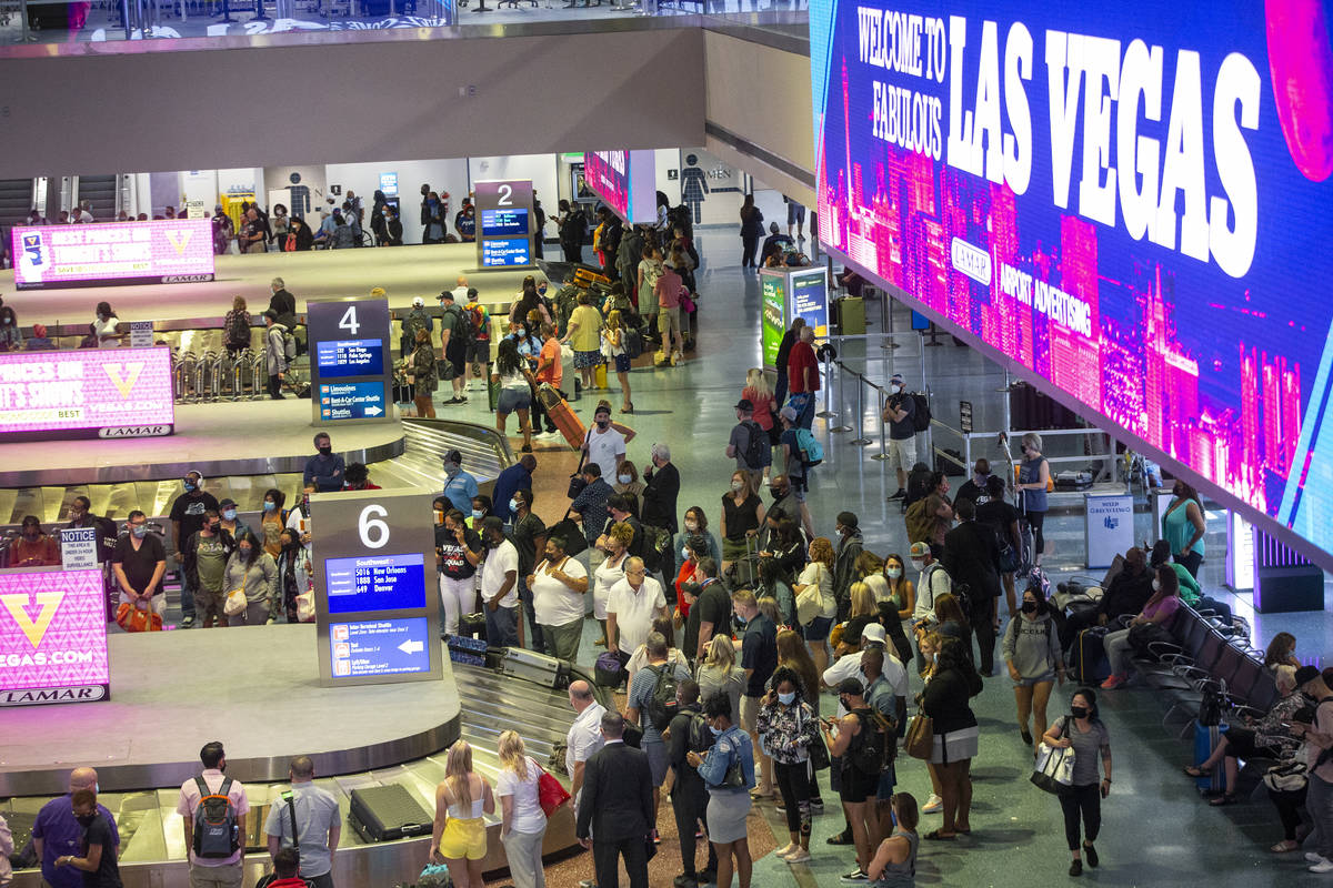 Travelers wait for their luggage at McCarran International Airport Terminal 1 in Las Vegas, Thu ...