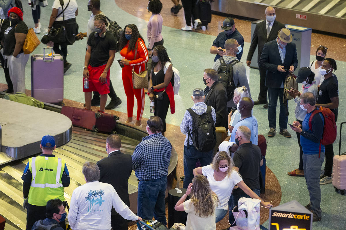 Travelers wait for their luggage at McCarran International Airport Terminal 1 in Las Vegas, Thu ...