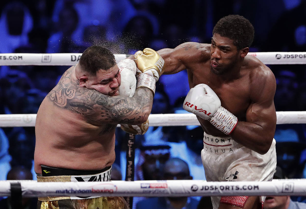 Defending champion Andy Ruiz Jr., left, takes a right cross to the face during his fight agains ...