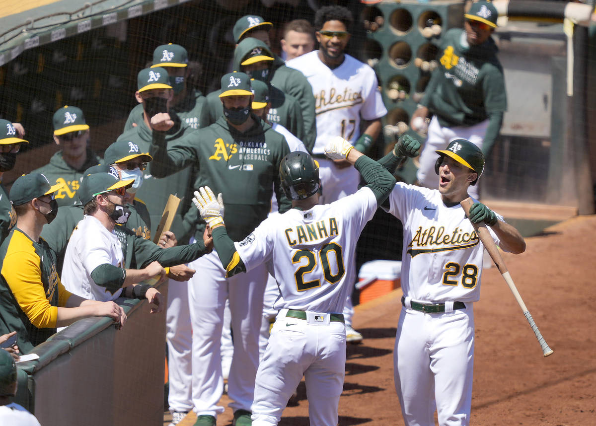 Oakland Athletics' Mark Canha (20) celebrates with Matt Olson (28) after hitting a solo home ru ...