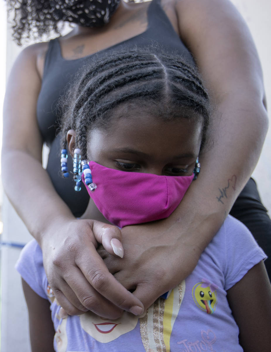 Marissa Neal embraces her daughter Shyla Hill, 6, during a vigil for 2-year-old Amari Nicholson ...