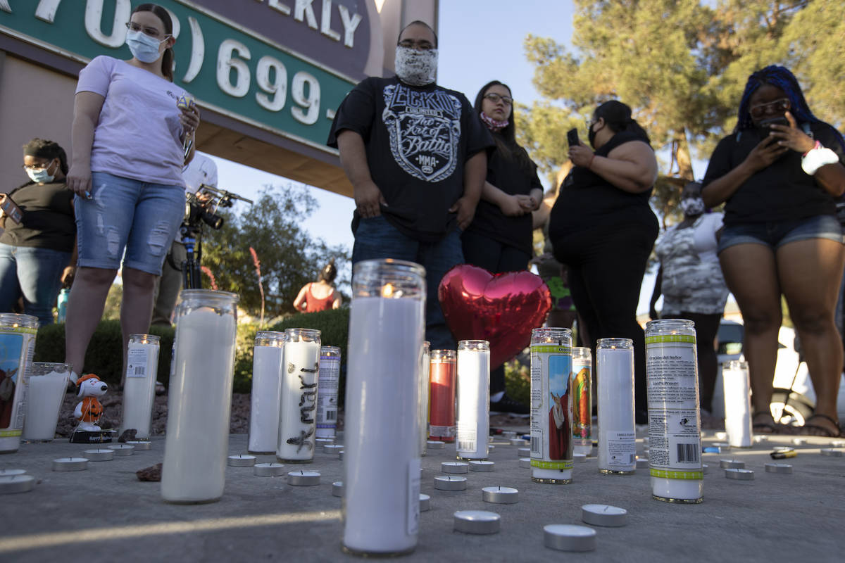 Mourners gather at a vigil for 2-year-old Amari Nicholson outside the Emerald Suites nearby whe ...