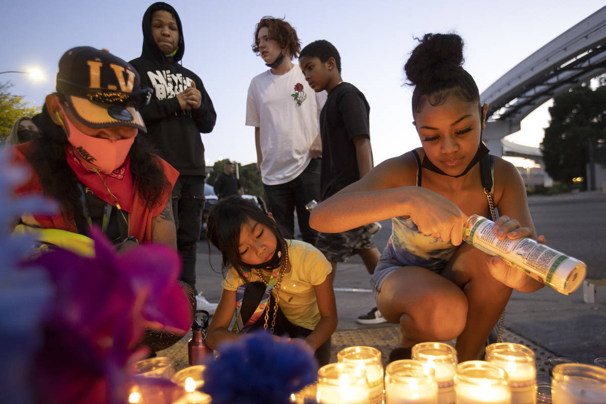 Ariyanah Nobriga, right, lights candles during a vigil for 2-year-old Amari Nicholson outside t ...