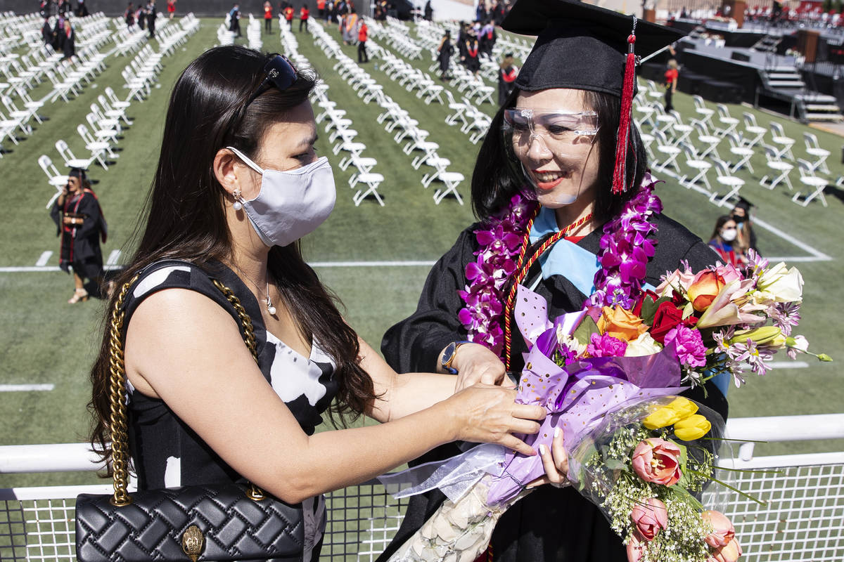 Thuanthi Huynh Tong-Hause, right, receives a bouquet of flowers from her friend Nhung Do after ...