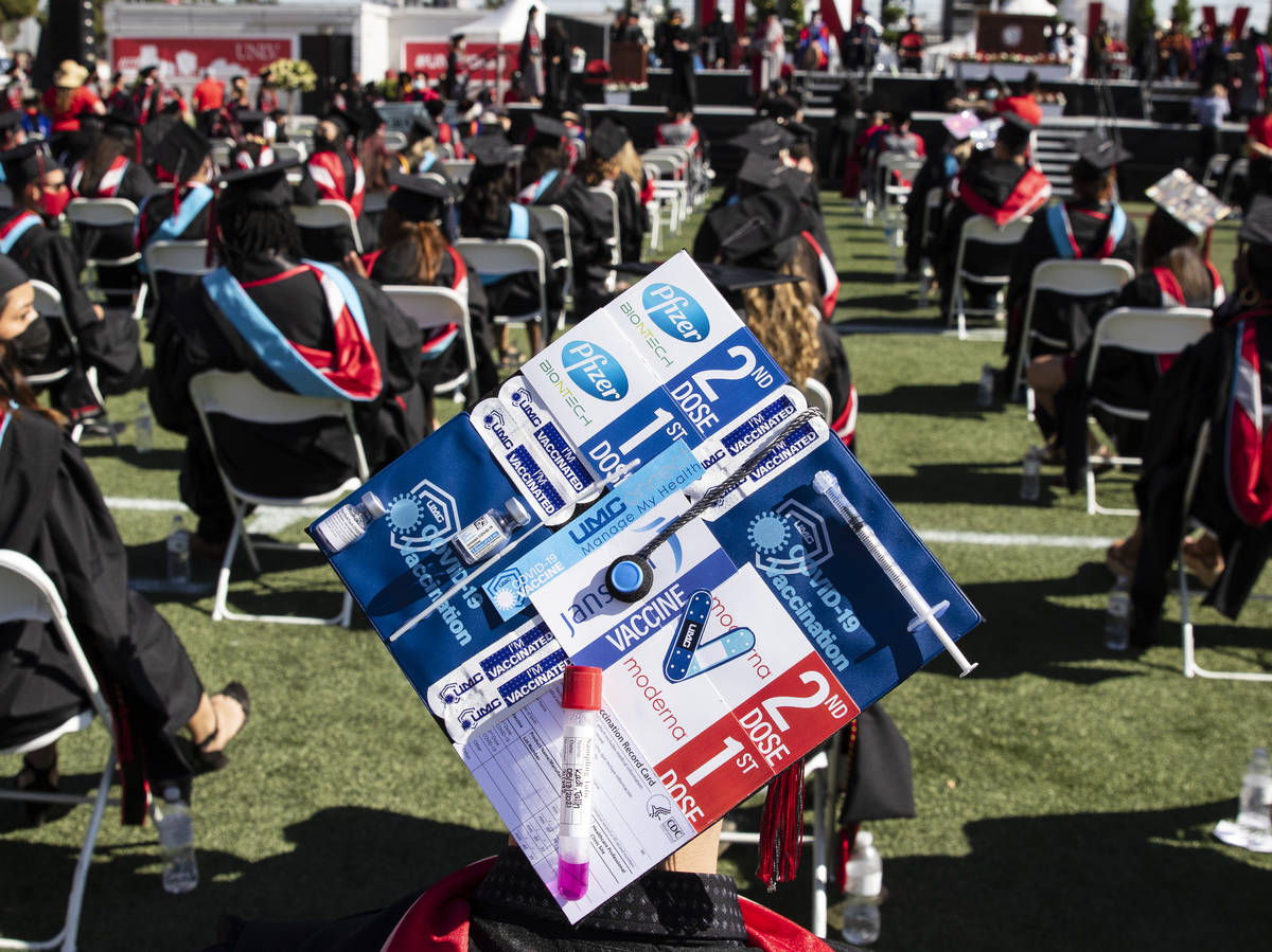 Talih Kadi decorates his graduation cap with COVID-19 and Pfizer themes during UNLV's graduatio ...