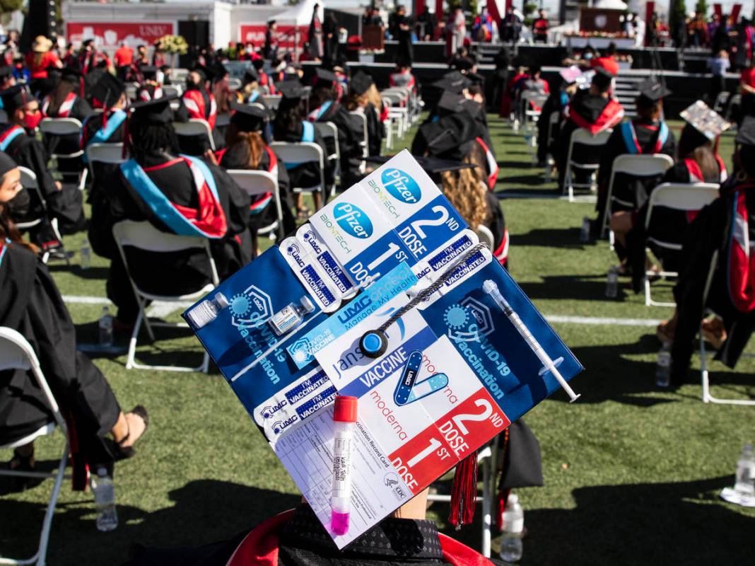 Talih Kadi decorates his graduation cap with COVID-19 and Pfizer themes during UNLV's graduatio ...