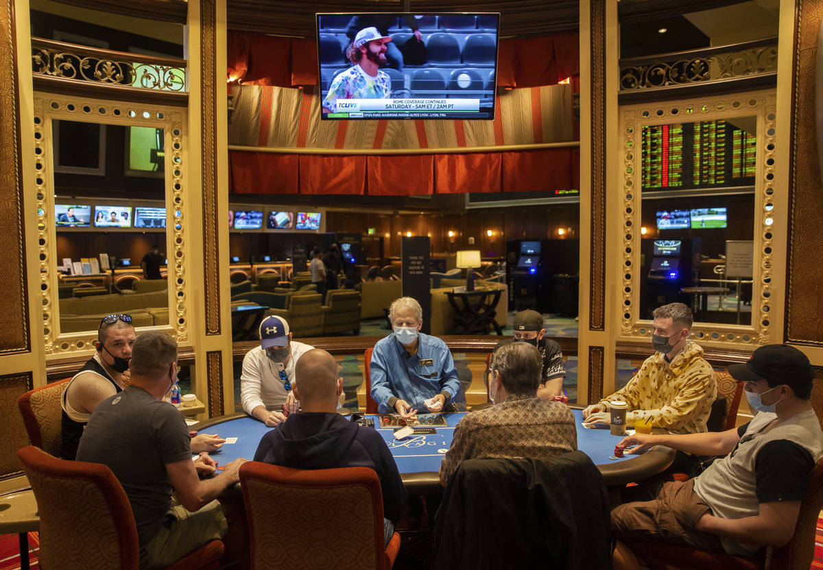 The poker tables at Bellagio are packed, with plexiglass barriers having recently been removed, ...