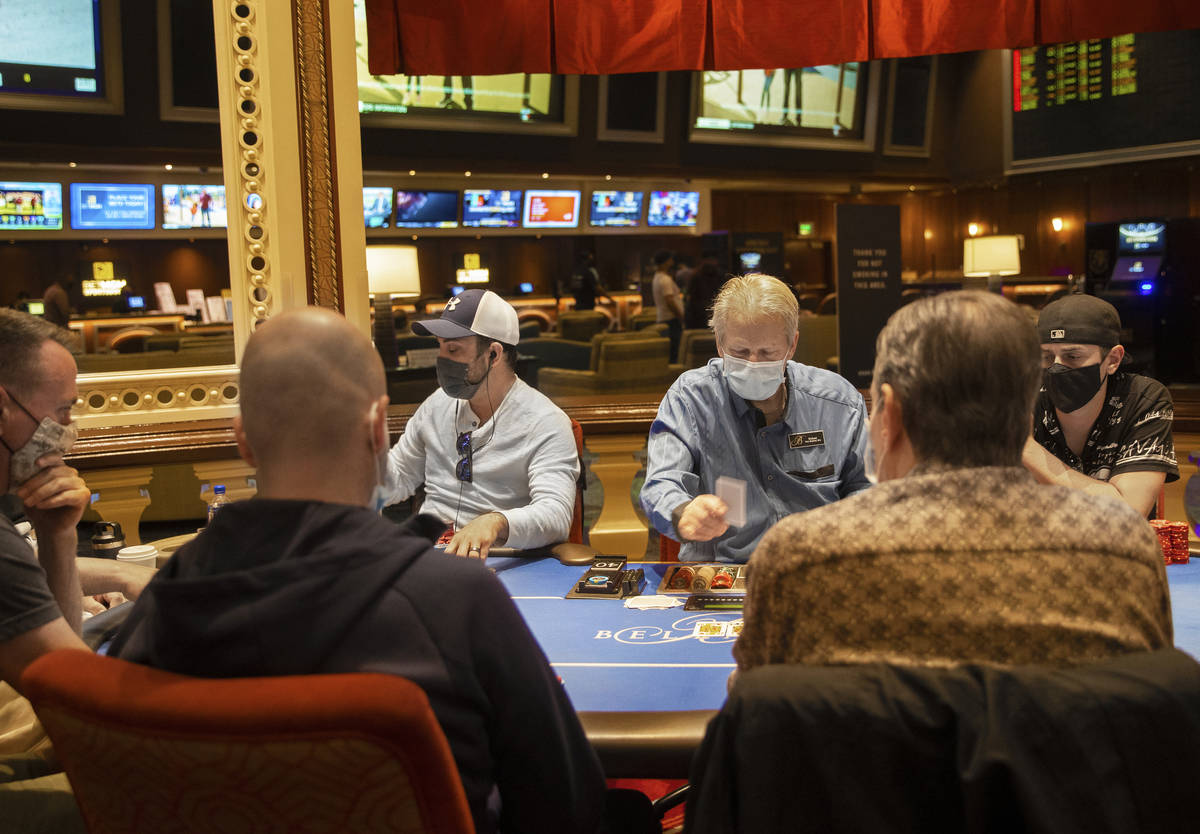 The poker tables at Bellagio are packed, with plexiglass barriers having recently been removed, ...