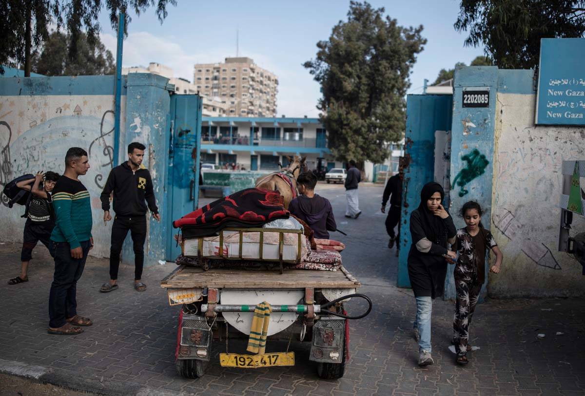 Palestinians flee their homes to a U.N. school after overnight Israeli heavy missile strikes on ...