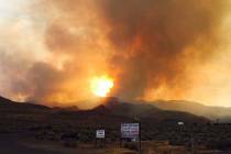 Smoke and flames are visible from a wildfire burning in the community of Sutcliffe, about 35 mi ...