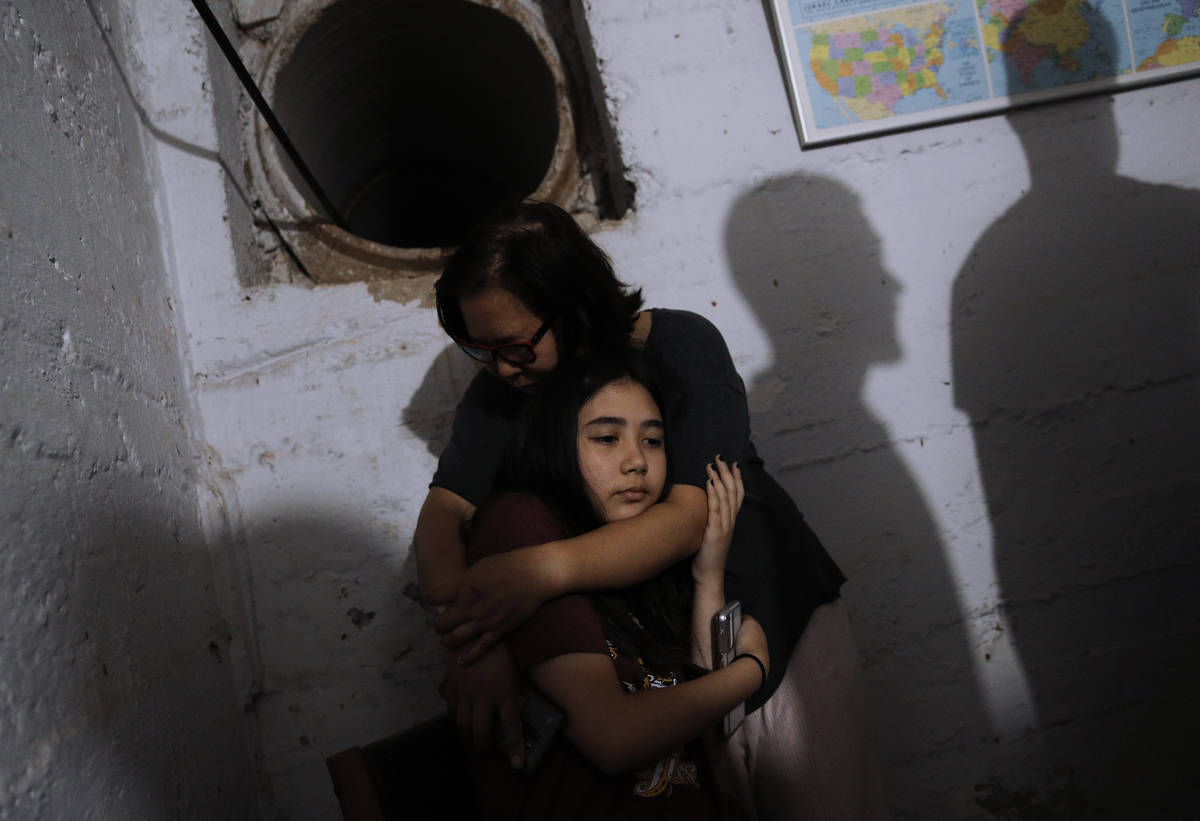 People take cover in a shelter as a siren sounds a warning of incoming rockets fired from the G ...