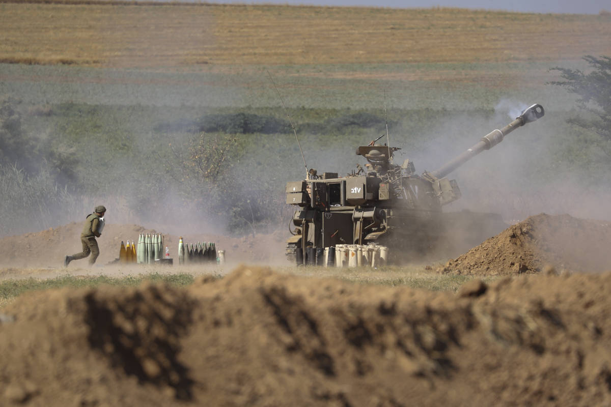 An Israeli artillery unit fires toward targets in the Gaza Strip, at the Israel-Gaza border, Sa ...