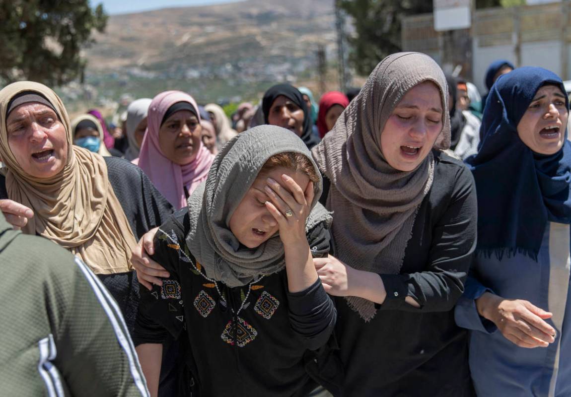 Palestinian mourners cry during the funeral of Husam Asayra, 20 in the West Bank village of Asi ...
