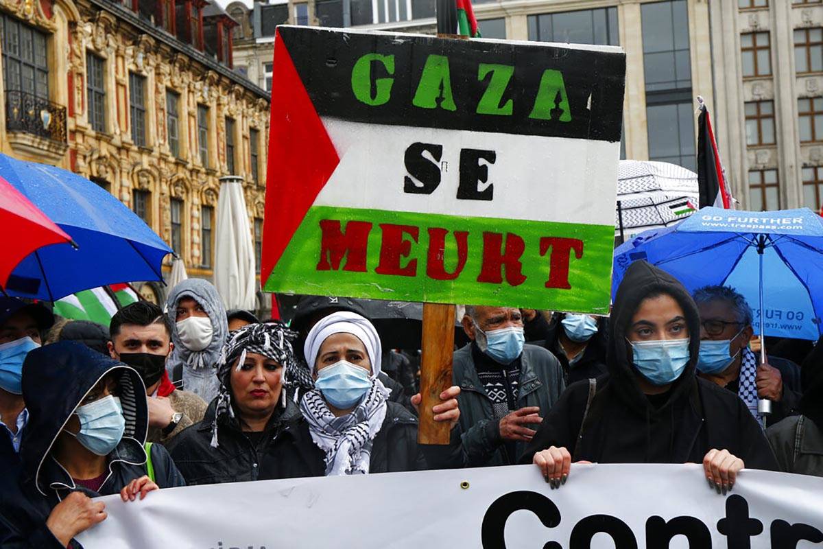 People hold Palestinian flags and banners during a demonstration in Lille, France, Saturday May ...