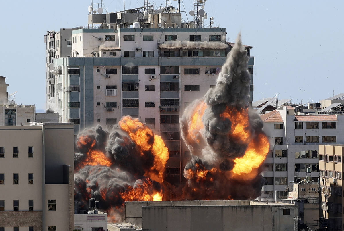 A ball of fire erupts from a building housing various international media, including The Associ ...