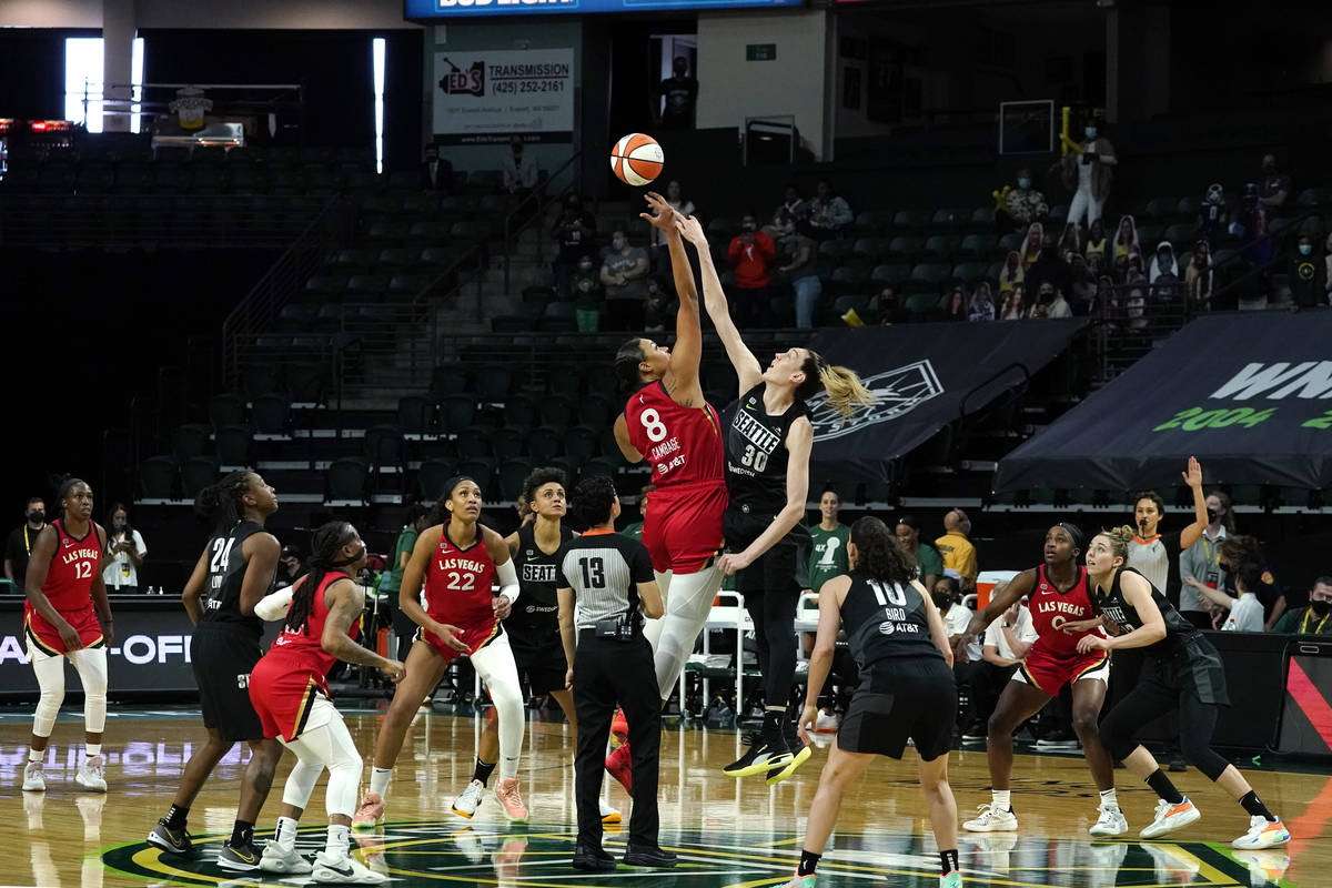 Las Vegas Aces' Liz Cambage (8) tips-off against Seattle Storm's Breanna Stewart to start the f ...