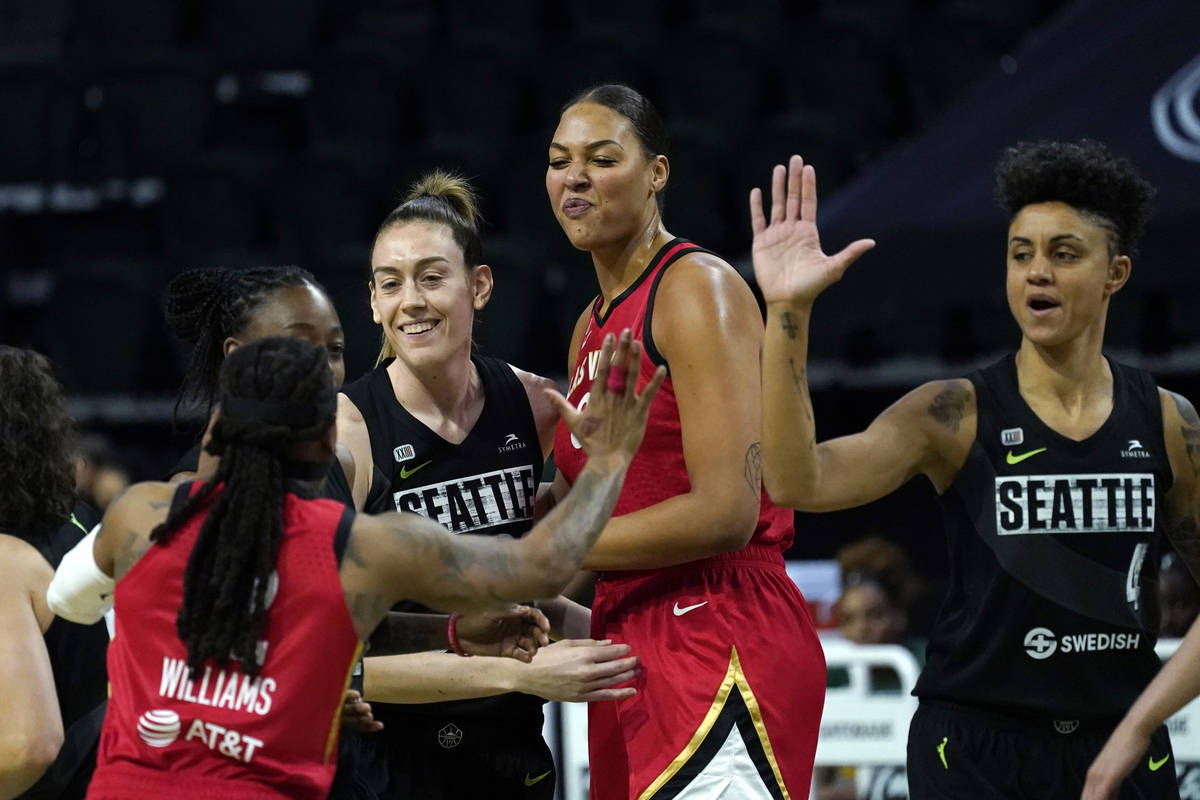 Seattle Storm's Breanna Stewart, second left, and Candice Dupree (4) greet Las Vegas Aces' Riqu ...