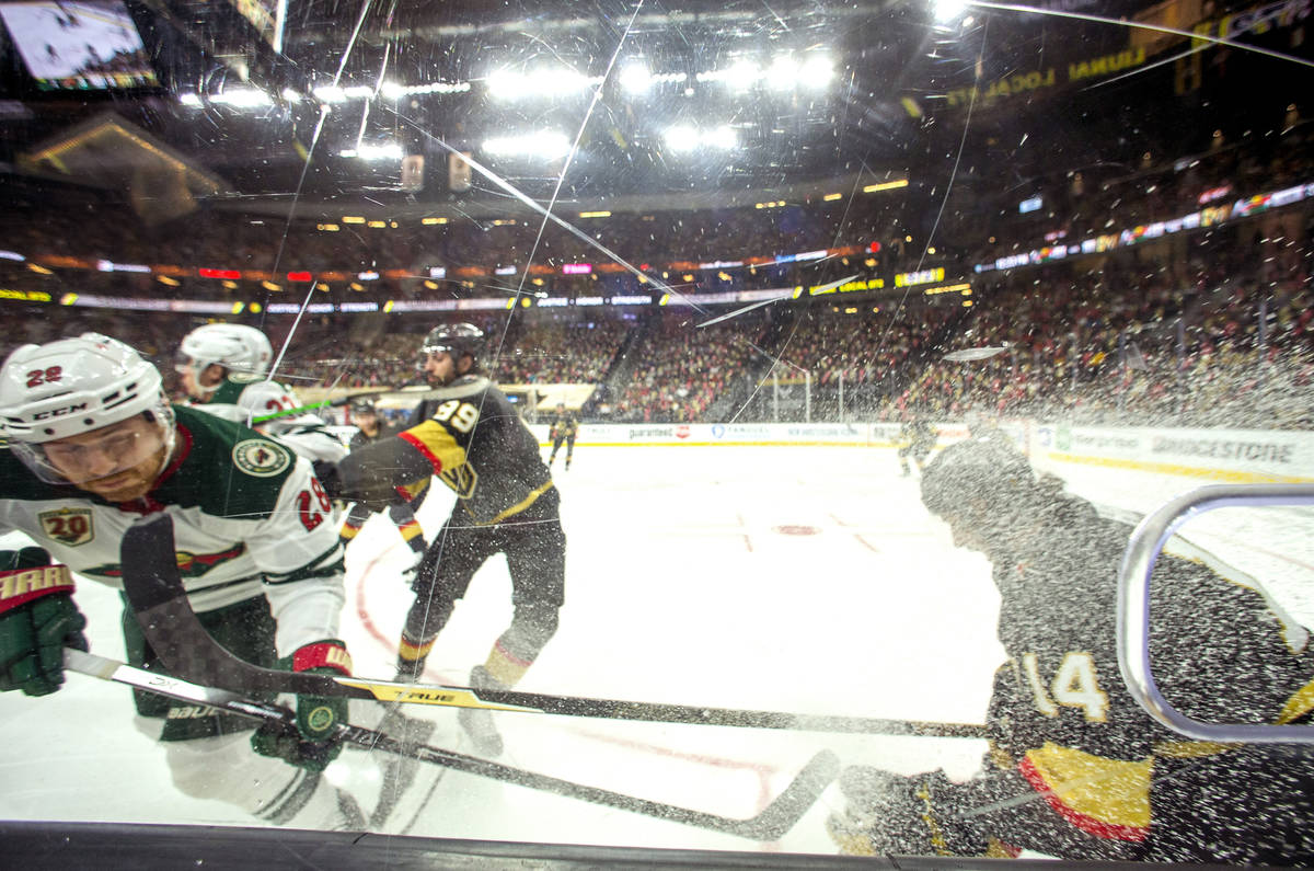 Golden Knights defenseman Nicolas Hague (14) battles the boards with Minnesota Wild defenseman ...