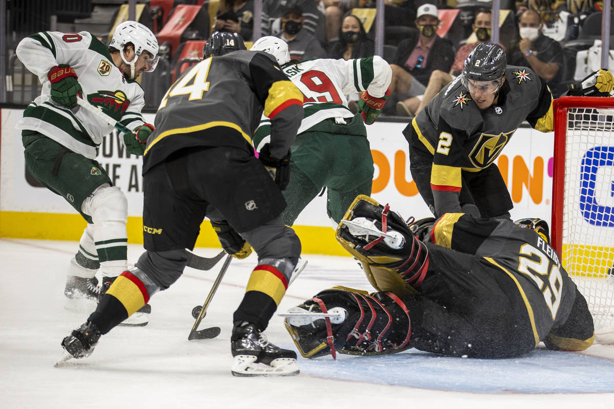 Golden Knights goaltender Marc-Andre Fleury (29) dives to the ice to assist teammate defenseman ...