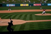 Milwaukee Brewers' Zach Green, left, gets ready for his at-bat in the shade as Arizona Diamondb ...