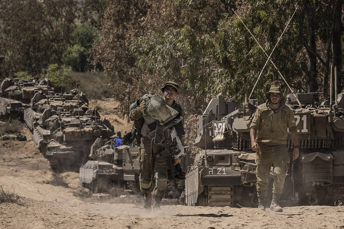 Israeli soldiers gather at a staging ground near the border with the Gaza Strip, in southern Is ...