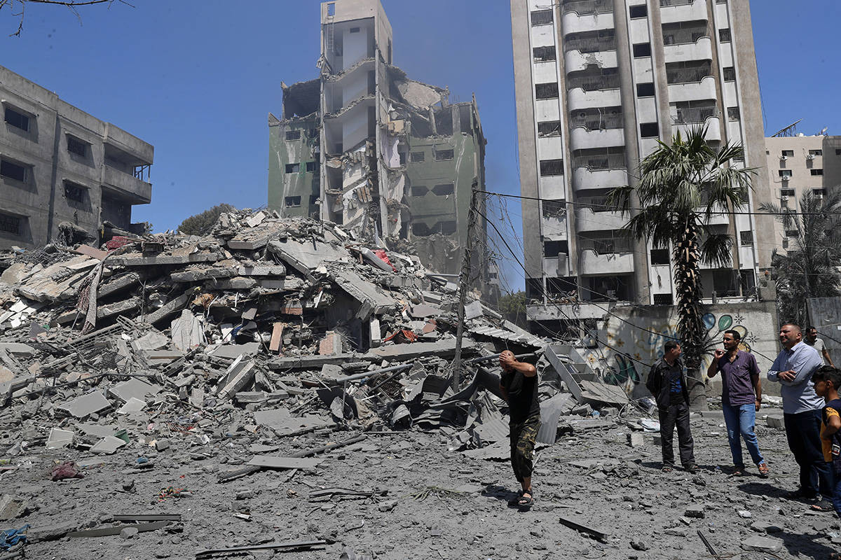 People inspect the rubble of a destroyed residential building that was hit by an Israeli airstr ...