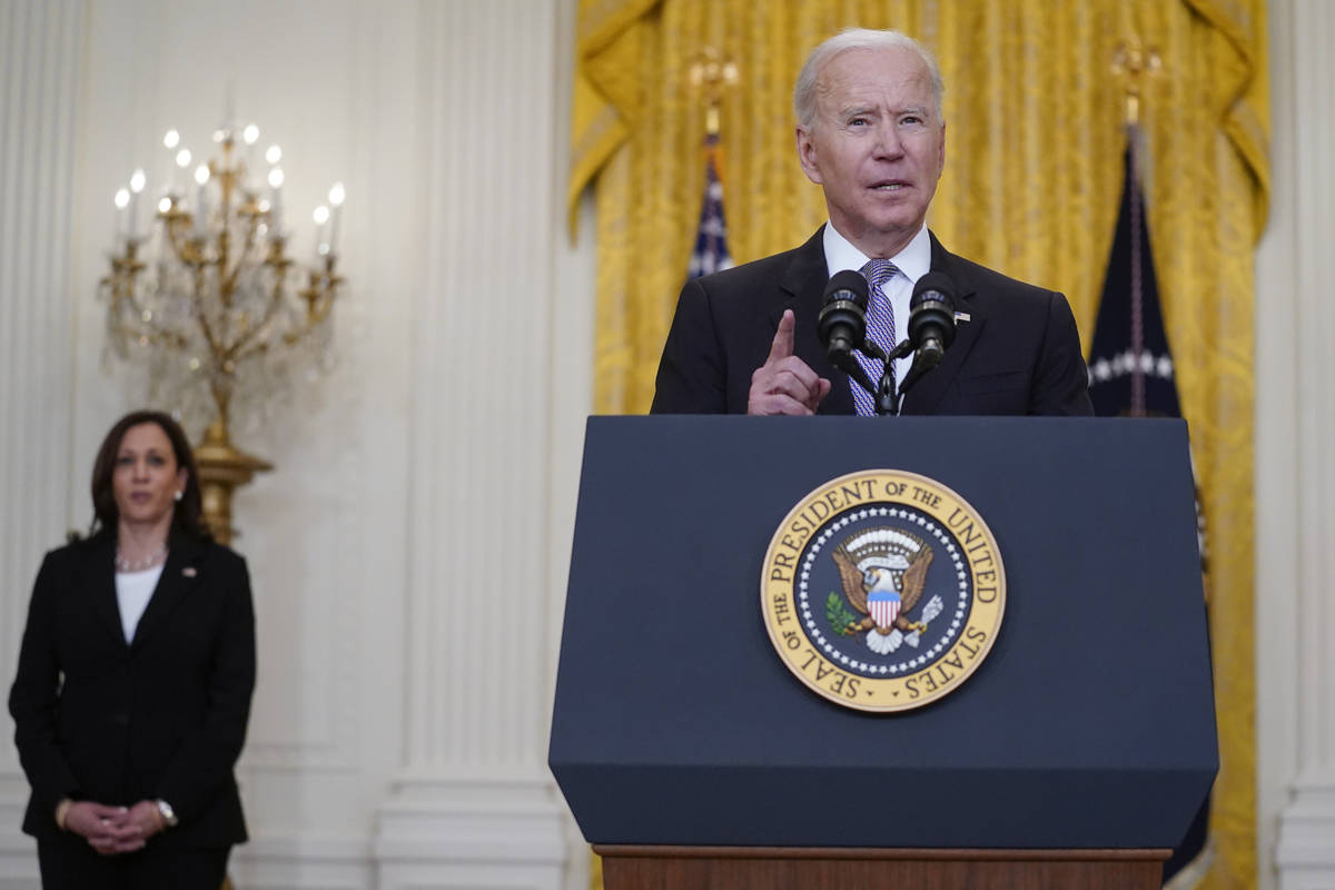 Vice President Kamala Harris listens as President Joe Biden speaks about distribution of COVID- ...