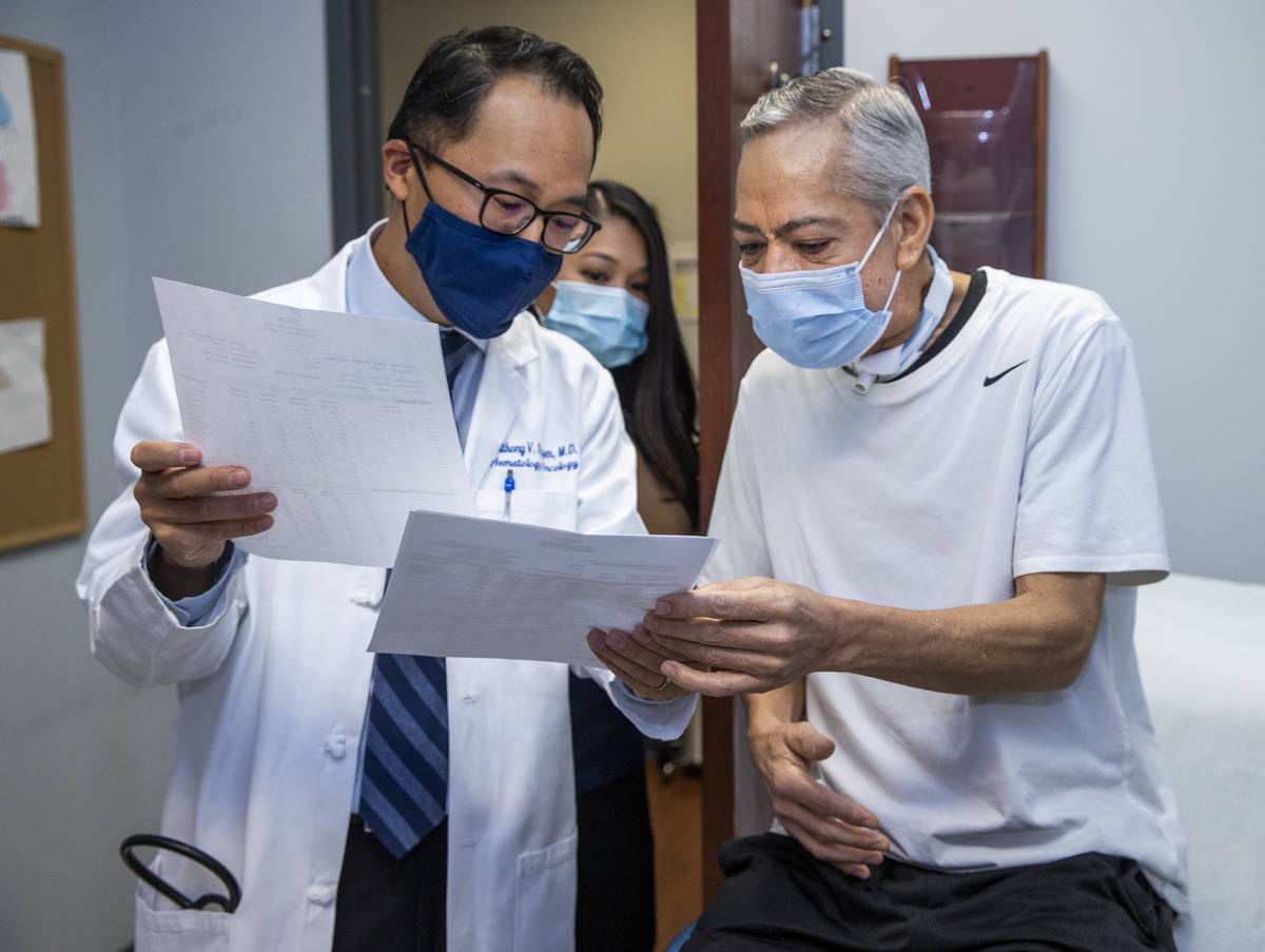 Dr. Anthony Nguyen, left, confers over test results with patient Ruben Solis at the Comprehensi ...